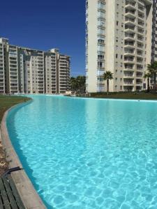 a large blue swimming pool in front of tall buildings at DEPARTAMENTO HERMOSO CON VISTA AL MAR in Algarrobo