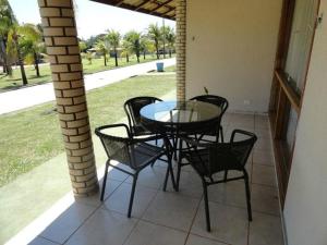 eine Terrasse mit einem Tisch und Stühlen auf einer Veranda in der Unterkunft Resort Campo Belo in Álvares Machado