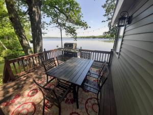 una mesa y sillas en un porche con vistas al lago en Sunrise Views Cabin with King Bed, Bar & Game Room, 