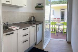 a kitchen with a sink and a balcony with a table at Apartments by the sea Okuklje, Mljet - 4912 in Maranovići