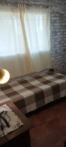 1 cama con manta a cuadros en una habitación en El paraíso de lupe en San Javier