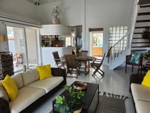 een woonkamer met een bank en een tafel bij Villa JADE, VUE MER, PISCINE PRIVEE, PLAGE A PIEDS in Le Gosier