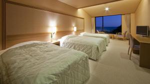 a hotel room with two beds and a desk at Kyukamura Nanki-Katsuura in Nachikatsuura