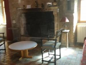 un soggiorno con tavolo, sedie e camino di Maison du XVe restaurée avec cheminée, jardin clos et bar privé - FR-1-410-127 a Crannes-en-Champagne 1 altra foto