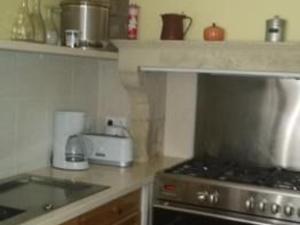 una cucina con fornelli e piano di lavoro di Maison du XVe restaurée avec cheminée, jardin clos et bar privé - FR-1-410-127 a Crannes-en-Champagne