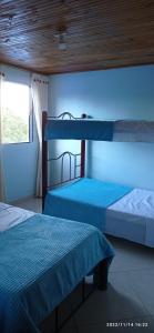 Duas camas num quarto com paredes azuis em Hostal El Balcon de madera em Norcasia