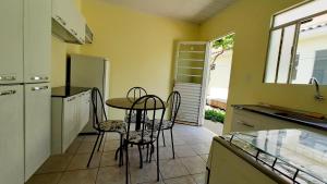 uma cozinha com uma mesa e cadeiras numa cozinha em hospedagensjaguariaiva em Jaguariaíva