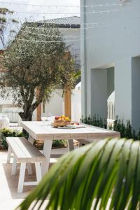 a white picnic table and bench on a patio at Motel Molly - Boutique Hotel Mollymook in Mollymook