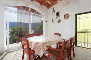 een eetkamer met een tafel en stoelen en een groot raam bij Apartments by the sea Poljica, Trogir - 16999 in Marina