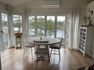 a dining room with a table and chairs and windows at Holiday home OSKARSHAM III in Oskarshamn