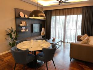 un soggiorno con tavolo, sedie e divano di LOVEly 2 bedrooms Premier Suite Vista FREE WIFI a Resorts World Genting