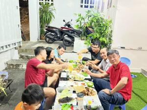 a group of people sitting around a table eating food at Homestay Vũng Tàu in Vung Tau