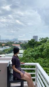 a woman sitting on a bench looking at the city at Homestay Vũng Tàu in Vung Tau