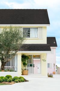 a white house with a black roof at Motel Molly - Boutique Hotel Mollymook in Mollymook