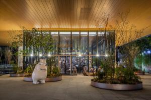 a large building with a large building with trees and a statue at TAI Urban Resort in Kaohsiung