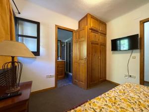 a bedroom with a bed and a cabinet and a mirror at Mirador del Valle Bed & Breakfast in Eriste