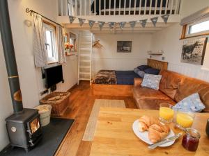 a living room with a couch and a table with bread at Shepherds Cabin at Titterstone in Farden