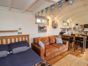 een woonkamer met een bank en een tafel bij Shepherds Cabin at Titterstone in Farden