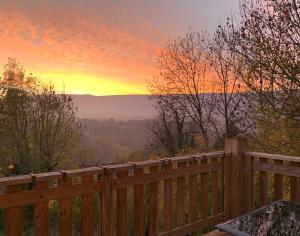 a wooden fence with a sunset in the background at Havre de paix - chambres dhotes in Bellegarde-sur-Valserine