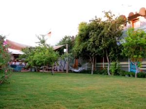 una casa con un patio con árboles y un campo en Yucca Alaçatı, en Alacati