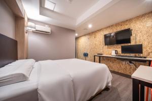 a hotel room with a white bed and a tv at 26 HOTEL in Anyang