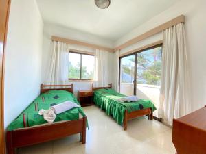 een slaapkamer met 2 bedden en een groot raam bij Kaan Hotel & Apartment in Kyrenia