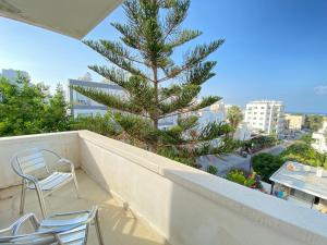 een balkon met 2 stoelen en een kerstboom bij Kaan Hotel & Apartment in Kyrenia