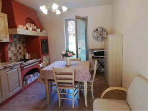 a kitchen with a table and chairs in a room at Villa Elisa in Saluzzo +9 photos