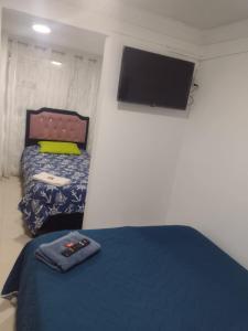 1 dormitorio con 1 cama y TV de pantalla plana en cerca a embajada americana Corferias centro club militar 201, en Bogotá
