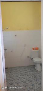 La salle de bains est pourvue de toilettes et d'un mur jaune. dans l'établissement Achita Cottages, à Senaru 62 autres photos