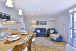 a kitchen and living room with a table and chairs at 7 Heaven in Mandurah