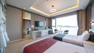 een hotelkamer met 2 bedden en een groot raam bij Hotel The One in Yeosu