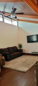 a living room with a couch and a flat screen tv at La Torre Azul in Alajuela