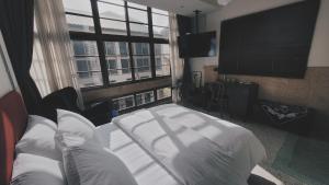 a bedroom with a white bed and a large window at Through A Path in Tainan