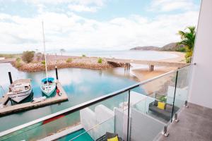 NEW! Dacha on Maggie No#2, Unrivaled Island Luxury في خليج نيللي: شرفة مطلة على قارب في الماء