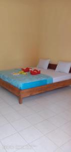 - un lit avec des draps bleus et des chaussures rouges dans l'établissement Achita Cottages, à Senaru