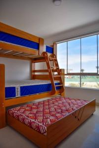 a bedroom with two bunk beds and a large window at Casa de playa: Disfruta de grandes momentos y del sol todo el año en Paracas in Paracas