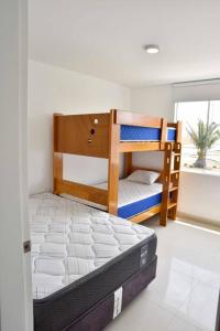a bedroom with two bunk beds and a window at Casa de playa: Disfruta de grandes momentos y del sol todo el año en Paracas in Paracas