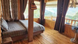 a bedroom with a bed and a large window at Tavan Dragon House in Lao Cai