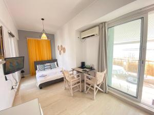 - une chambre avec un lit, une table et un balcon dans l'établissement Lycabetus View Loft Downtown Kolonaki, à Athènes
