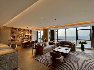 a living room with couches and a table and windows at Wanda Jin Xiaohe Xincheng in Taiyuan