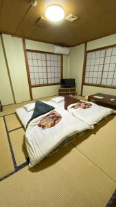 - une chambre avec un grand lit dans une pièce dotée de fenêtres dans l'établissement 民宿ニュー万福茶屋, à Taketa