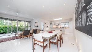 a kitchen and dining room with a table and chairs at Pearl Beach House in Pearl Beach