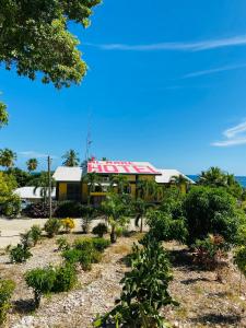 una casa amarilla con techo rojo en una playa en Hotel Al Mare en Santa Cruz de Barahona