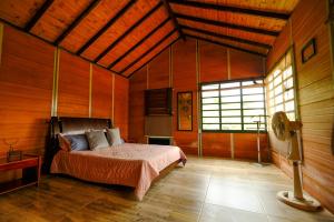 a bedroom with a bed in a room with wooden walls at Cabañas El Morichal in San José del Guaviare