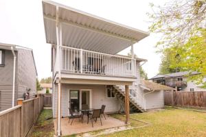 a house with a deck with a table and chairs at CHEERFuL 2 LEVEL HOUSE 4 BED 3 BATH PARKiNG in Delta