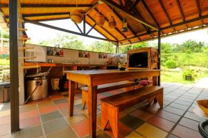 a kitchen with a wooden table and a bench at Cabañas El Morichal in San José del Guaviare