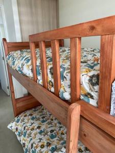 ein Etagenbett aus Holz mit einer Bettdecke mit Blumen in der Unterkunft Arriendo Departamento Nuevo, Algarrobo Norte in Algarrobo + 26 Fotos