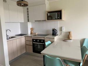 eine Küche mit Spüle und Herd oberen Backofen in der Unterkunft Arriendo Departamento Nuevo, Algarrobo Norte in Algarrobo