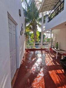 un pasillo con una puerta, una mesa y una palmera en Bonito departamento con alberca en Cancún, en Cancún